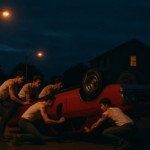 Cinematic evening scene, dark blue sky, orange street lamps casting warm pools of light on a quiet suburban road, a group of young European men in white tank tops and jeans with eagle tattoos surrounding a bright red 1967 Chevrolet Impala, flipping it onto its roof, a two-story house behind them with a single window lighting up, moody thriller atmosphere, deep shadows, high contrast, film grain